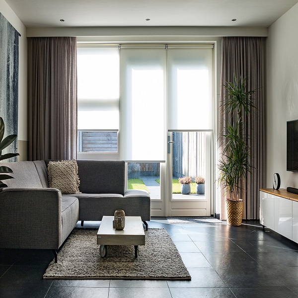 odern living room with light-filtering honeycomb blinds and dark blackout curtains.